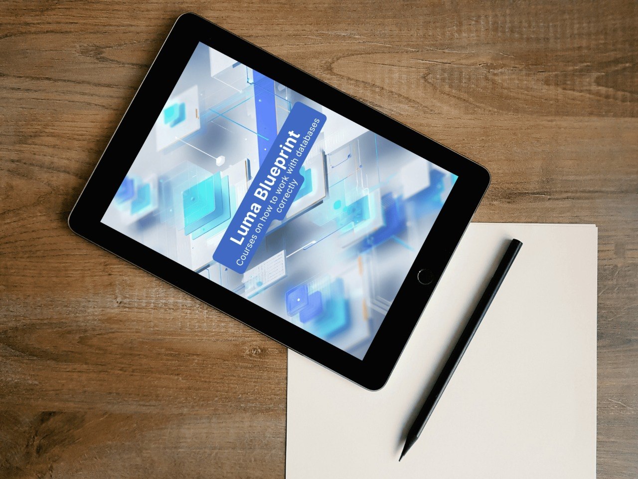 Tablet displaying a Luma Blueprint on a wooden surface with a pen and paper.